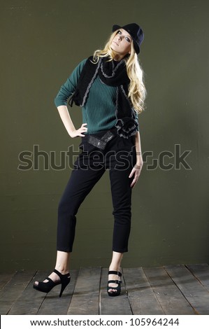 Full length portrait of pretty young woman in hat posing wooden floor
