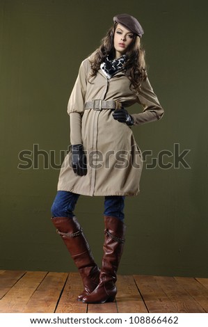 full body fashion woman in coat dress posing wooden floor on dark background