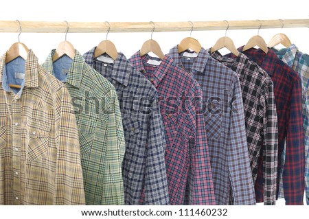 A row of colorful row shirts hanging on hangers on a white background