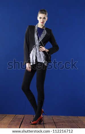 full body fashion woman in elegant dress posing wooden floor on blue background