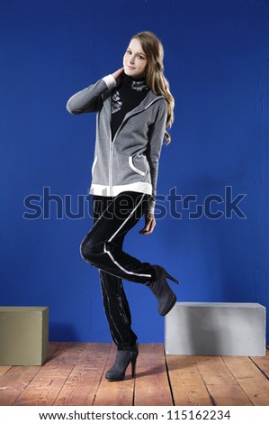 Full length portrait of pretty young woman posing with cube