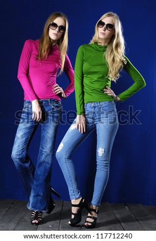 Full body fashion casual two girl standing in sunglasses posing wooden floor