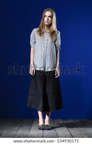 Full length fashion girl standing posing on wooden floor