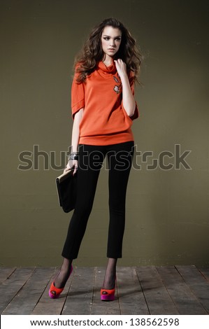 Beautiful full body young fashion model holding purse posing