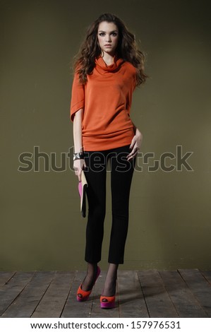 Full length portrait of young woman posing wooden floor