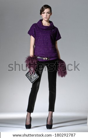 Full body beautiful girl is in fashion style holding purse on gray background