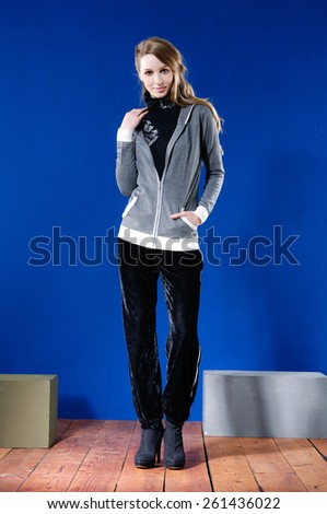 Full length fashion girl with cube standing posing on wooden floor