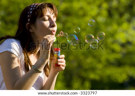 The girl inflates soap bubbles in the warm spring afternoon
