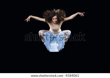 The dancer beautifully flying to a jump on a black background