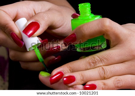 The master does manicure to the girl of bright green color