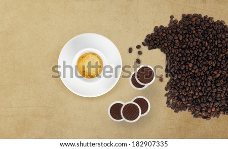 cup of coffee with beans, coffee pods on marble table