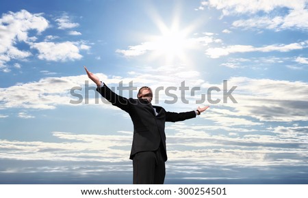business man on top of success, open arms to the sky