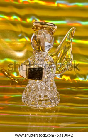 Vintage glass angel figurine on golden stripped background