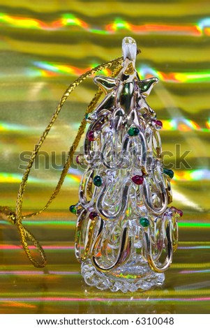 Vintage glass xmas-tree decoration on golden stripped background