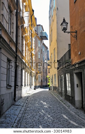 Empty street in the old center, Gamla Stan, Stockholm, Sweden, at early sunny summer morning.