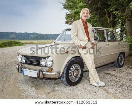 An image of a handsome man in front of his historic car