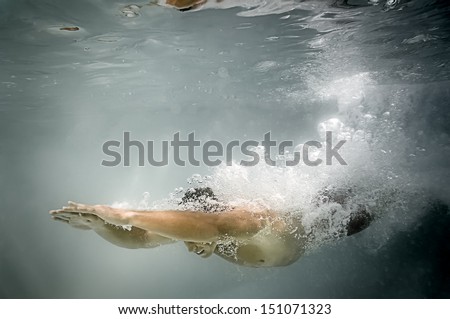 An image of a man diving in the pool with lots of air bubbles An image of a man diving in the pool with lots of air bubbles