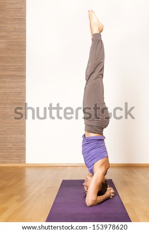 An image of a pretty woman doing yoga - Salamba Shirshasana Head Stand