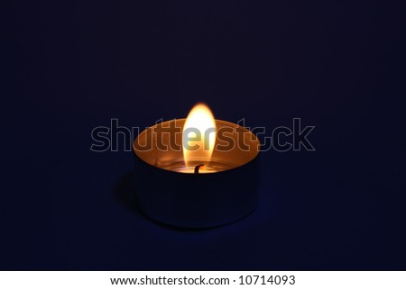 A tealight candle with dark background