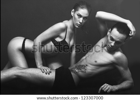 Passionate sexual couple posing at the studio wtith fume isolated on black background