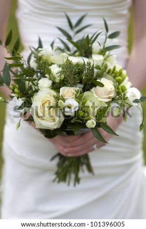 bride holding a bouquet of flowers with roses