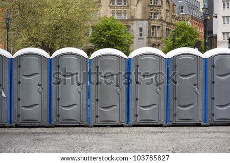 portaloos outdoors at an outdoor event in a line or row