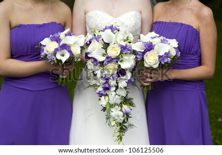 bride and bridesmaids with purple wedding bouquets