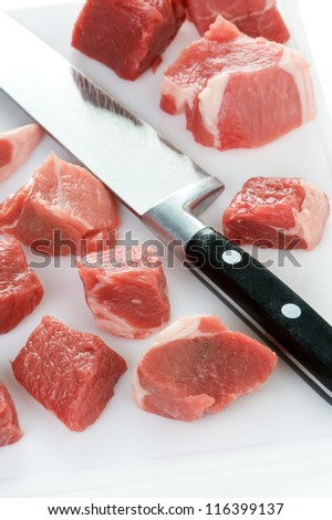 raw lamb diced with kitchen knife and chopping board