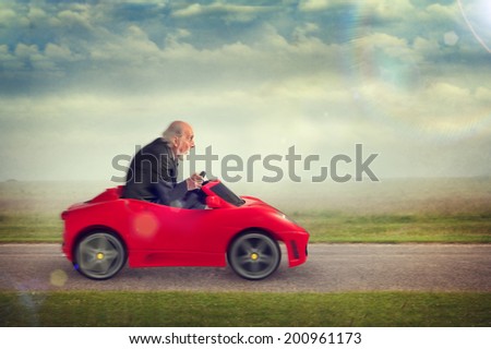senior man enjoying driving a toy racing car