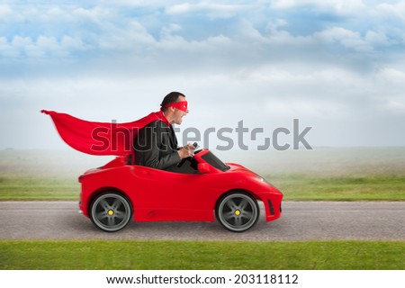 superhero man driving a red toy racing car at speed