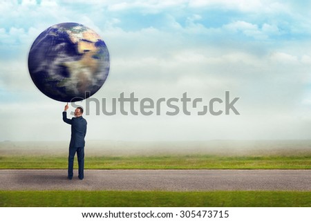 businessman holding spinning planet earth aloft with one finger subtle vintage filter and selective focus with copy space