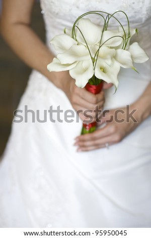 bride holding a wedding bouquet of fresh lilies