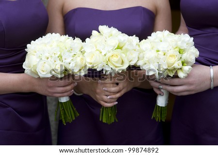 three bridesmaids holding wedding bouquets