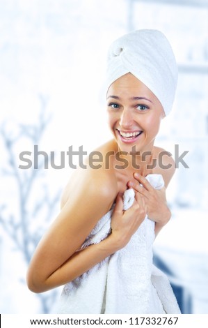 Modest  young woman holding a towel to cover herself