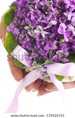 Wedding violet bouquet in the hands of a bride