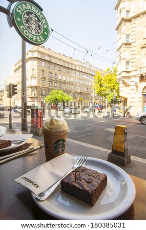 BUDAPEST, HUNGARY - JULY 8, 2013: Starbucks glass of coffee and brownie cake in coffeehouse on July 8, 2013 in Budapest, Hungary. Starbucks is the world\'s largest coffeehouse company.