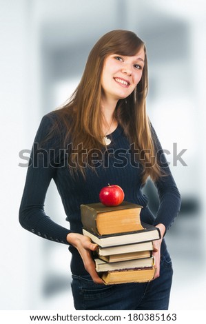 Cheerful student woman holding books and apple