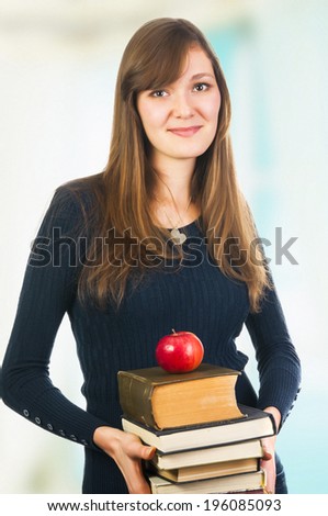 Attractive student woman holding books and apple