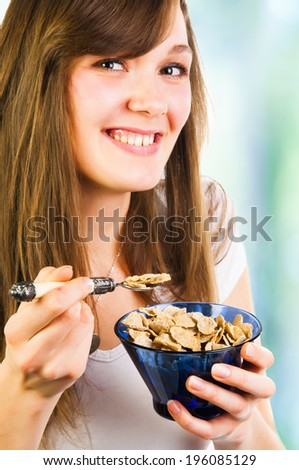 Happy beautiful woman eating cereal