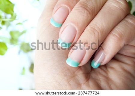 Female nails with beautiful manicure design and fresh mint leaves