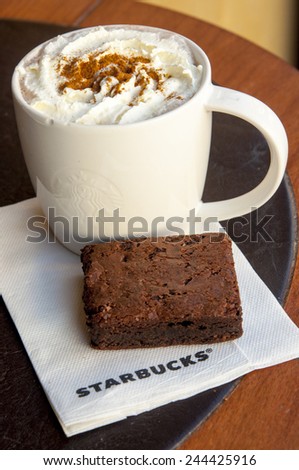 LONDON, UNITED KINGDOM - FEBRUARY 16, 2014: Cup of hot chocolate and brownie cake in in Starbucks coffee in London on February 16, 2014, UK