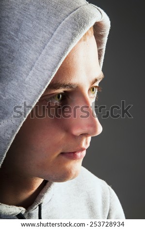 Side view portrait on handsome man in hood on gray background