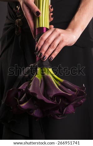 Black Calla Lilies bouquet in the hand of a woman