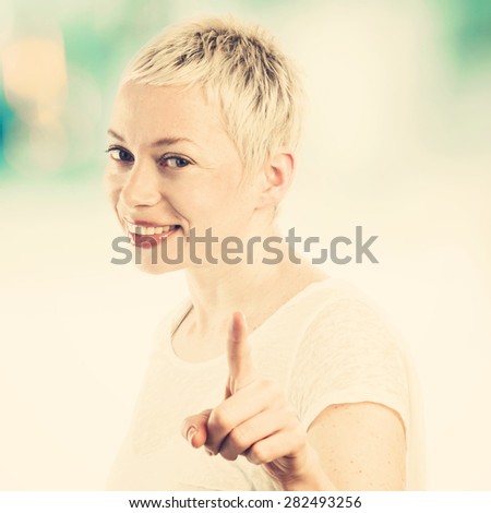 Young woman looking at camera, pointing you and smiling, instagram style filter