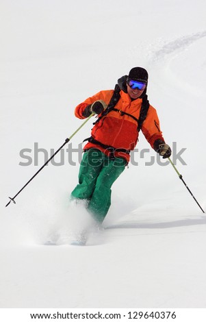 Handsome man skiing fresh powder snow.
