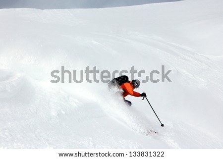 Rugged man skiing fresh powder snow.