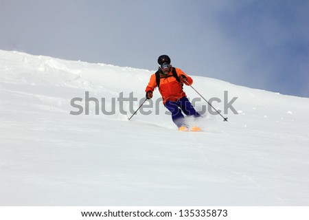 A man smiles as he skis fresh powder snow in the Utah mountains, USA.