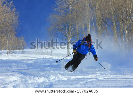 Skier charging down a slope in the Utah mountains, USA.