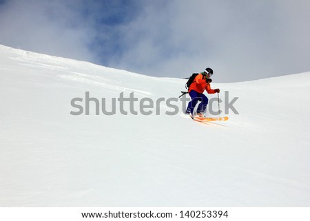 A man skiing down an untracked slope in the Utah mountains, USA.
