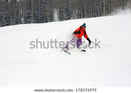 A woman blasting through fresh powder snow in the Utah mountains, USA.